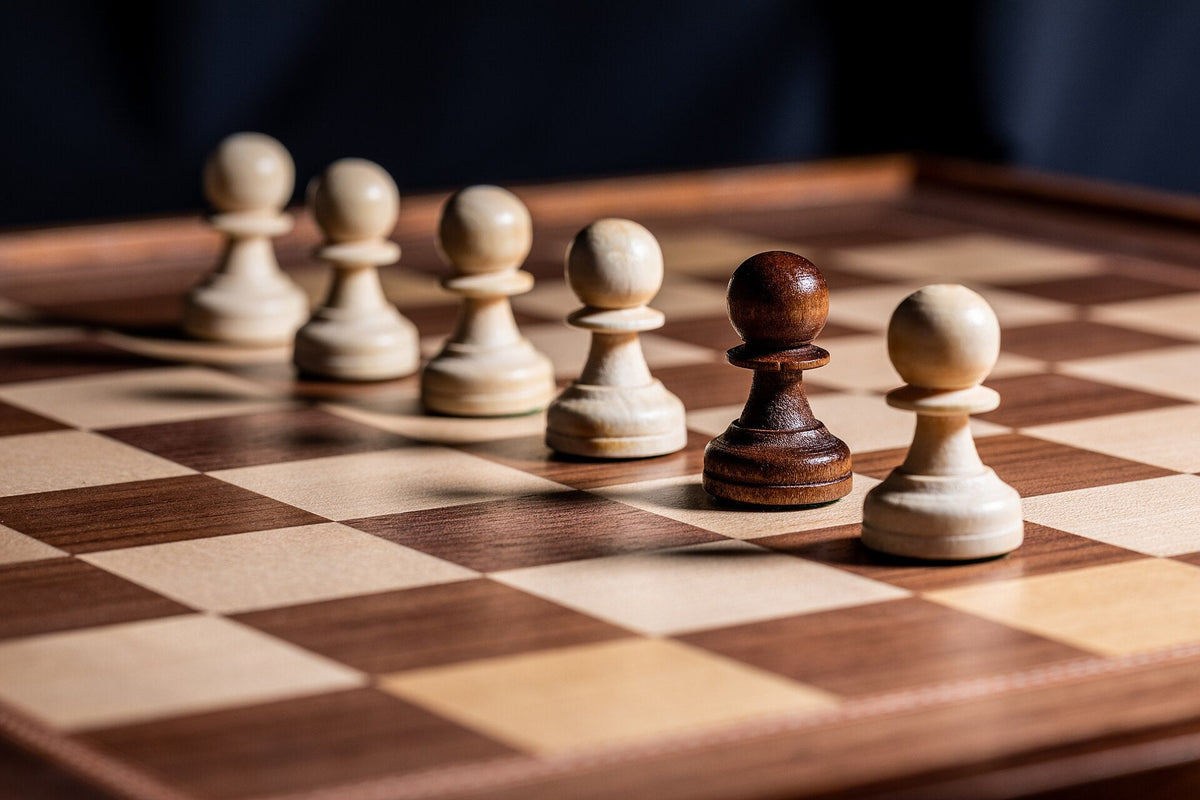 Wooden pawns on a walnut and maple chess board